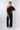 Front view of black Gigi Asymmetrical One-Shoulder Knit Jumpsuit one-shoulder silhouette relaxed fit resort