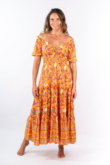 Front view of floral yellow gold Ginger Sweetheart Ruffle Maxi Dress sweetheart neckline maxi silhouette resort